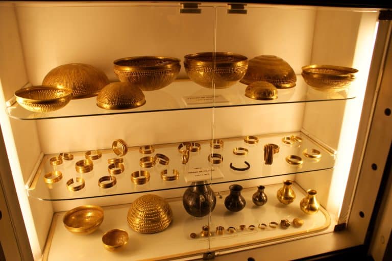 Gold bowls, bracelets, bottles and ornaments from the Treasure of Villena are arranged together in a museum display.