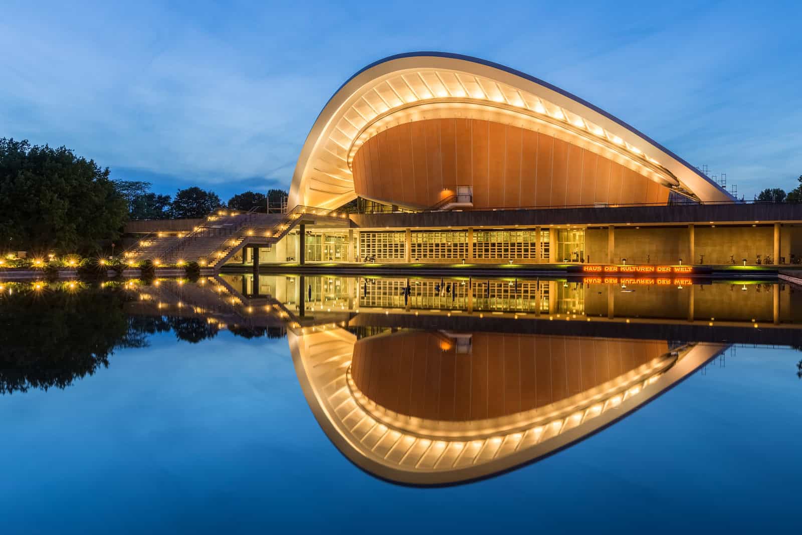 Haus der Kulturen der Welt reflected in a pool at blue hour in Berlin.