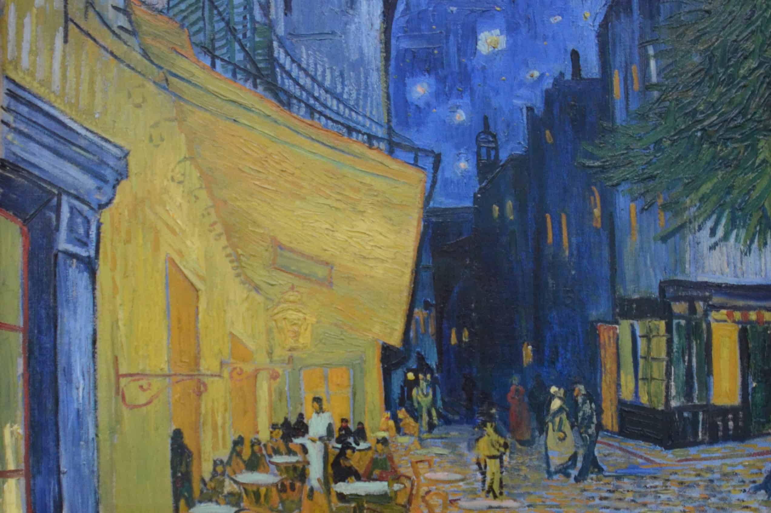Vincent van Gogh’s Café Terrace at Night glows yellow beneath a deep blue, star-filled sky.