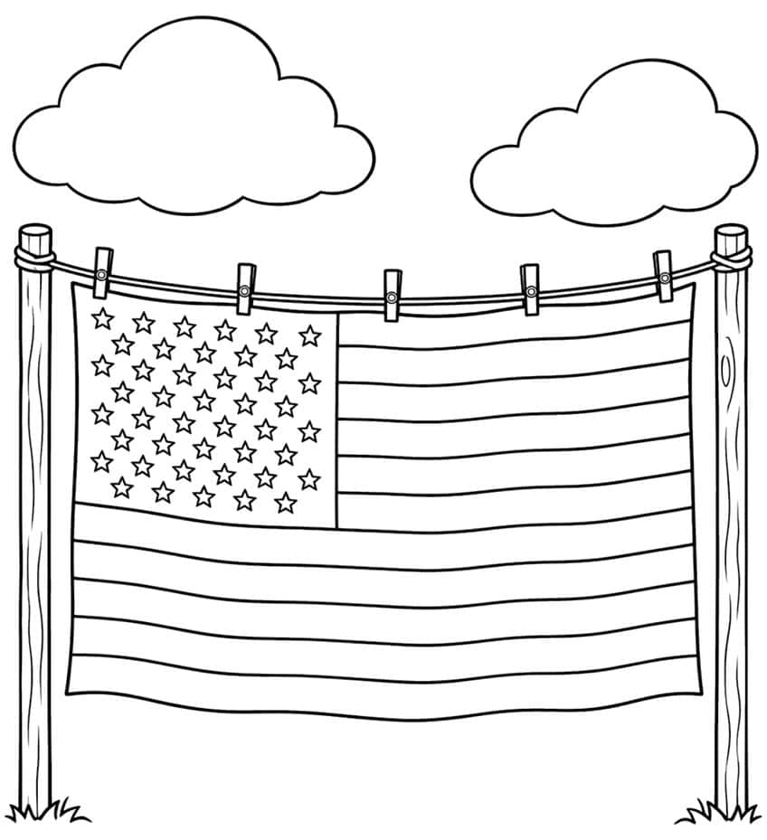 American flag pinned with five clothespins to a line between two wooden posts, with two clouds above