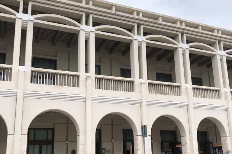 The white arched façade of Centro Cultural Olimpo in Mérida beneath a deep blue sky.