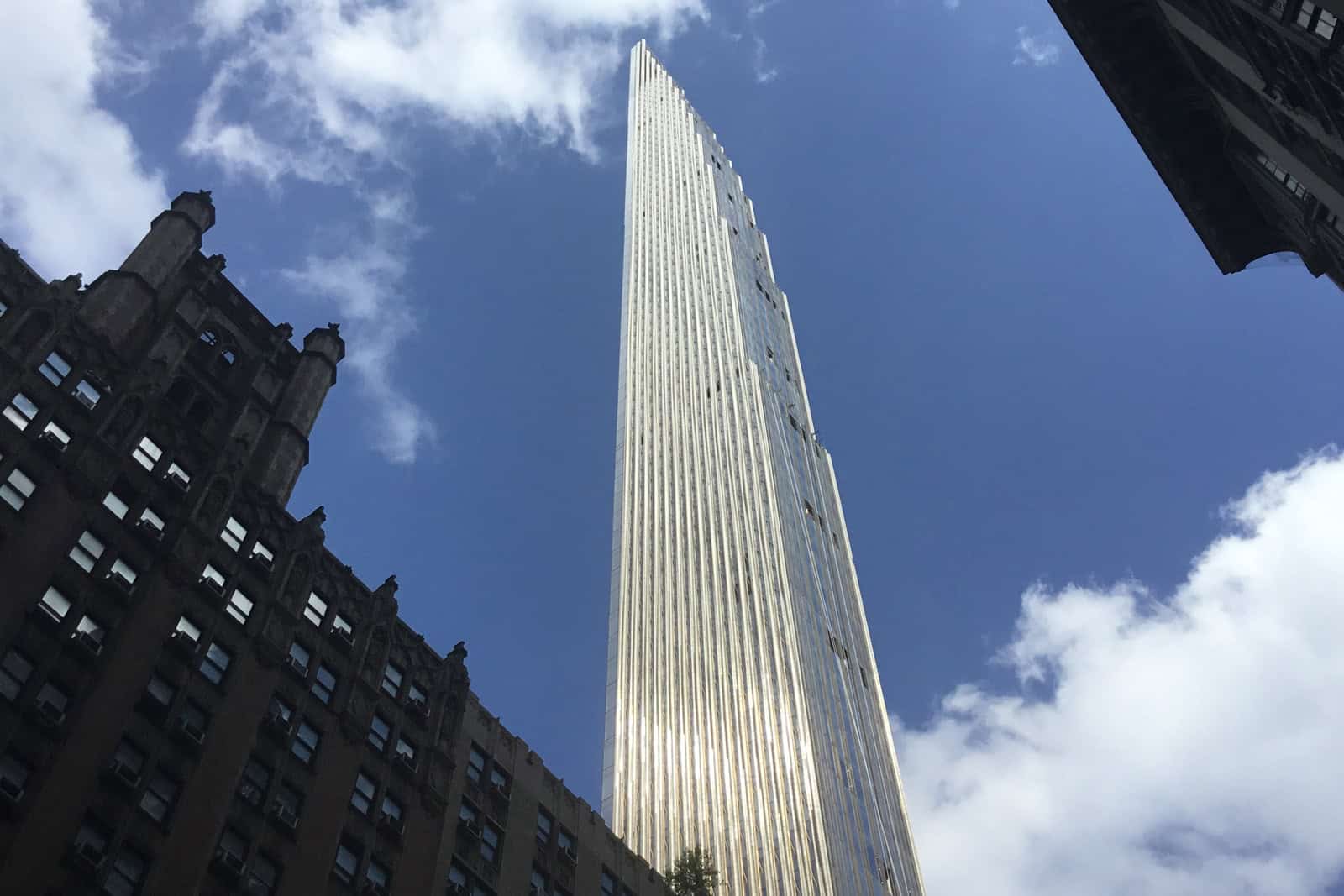 The slender tower at 111 West 57th Street rises above its historic stone base in Midtown Manhattan.