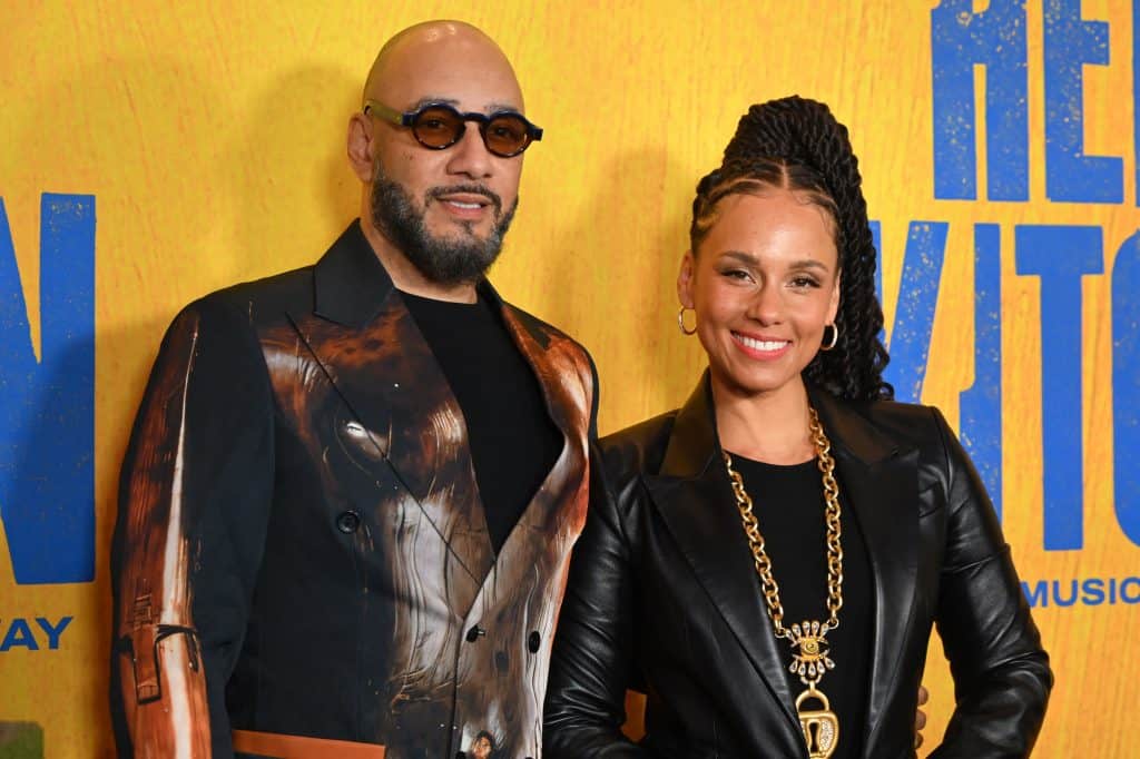 Kasseem “Swizz Beatz” Dean and Alicia Keys stand together and smile at a Broadway event in New York.