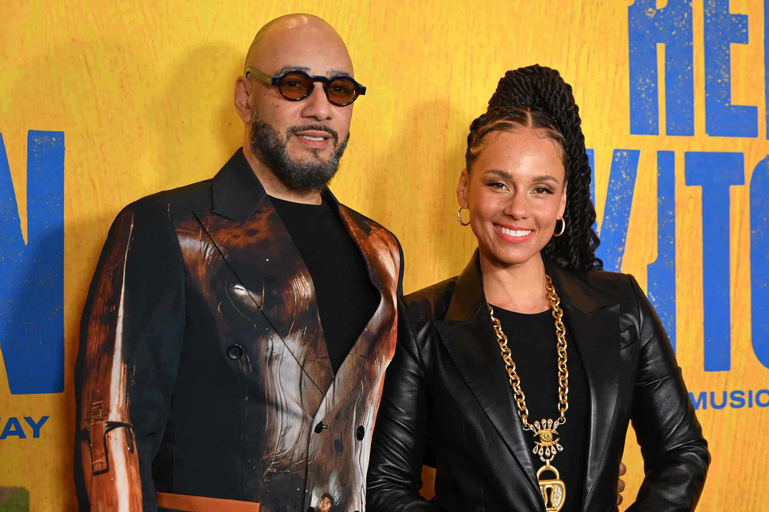 Kasseem “Swizz Beatz” Dean and Alicia Keys stand together and smile at a Broadway event in New York.