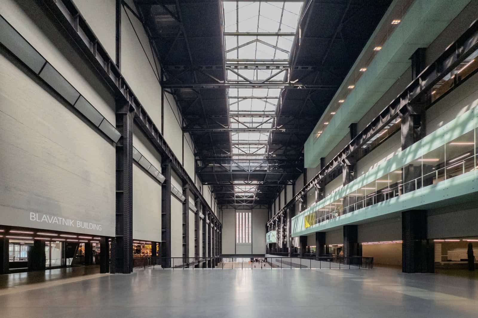 Visitors walk through the tall industrial interior of Tate Modern’s Turbine Hall.