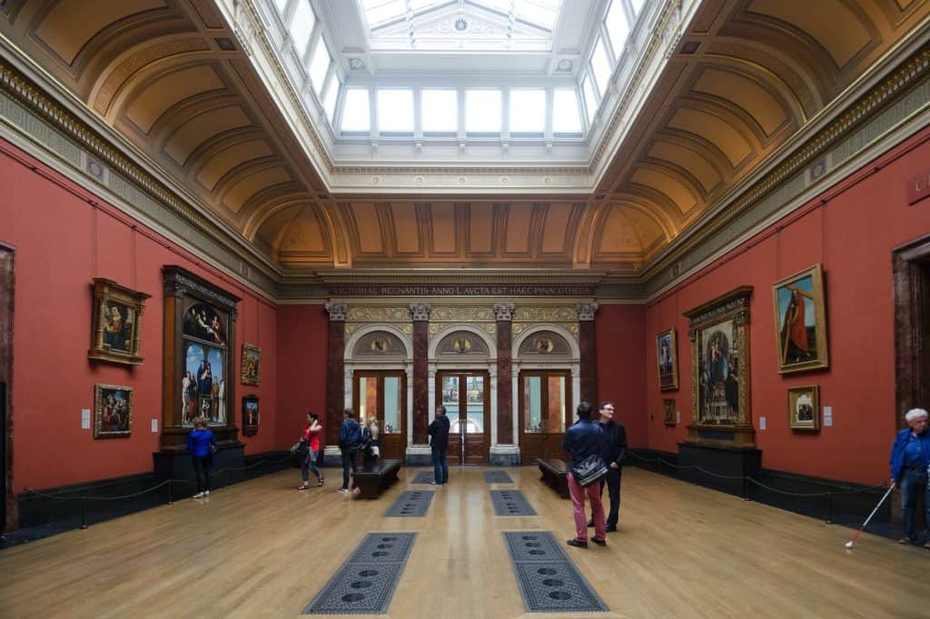 Paintings line the arched galleries opening from the National Gallery’s Central Hall in London.