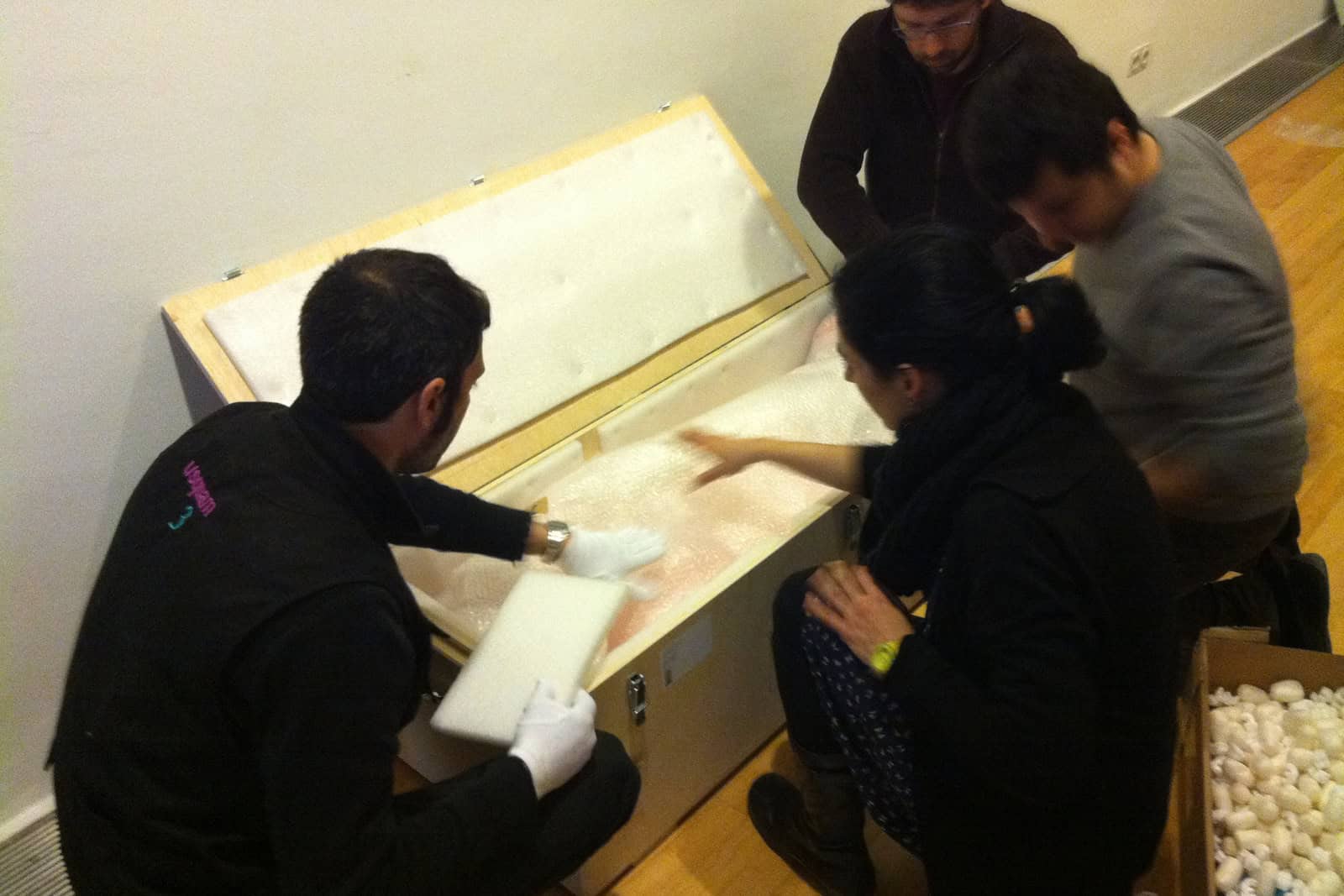 Museum workers handling a sculpture during exhibition deinstallation