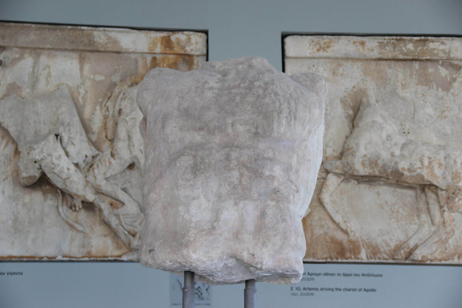 Parthenon pediment fragments and pale casts are arranged together inside the Acropolis Museum.