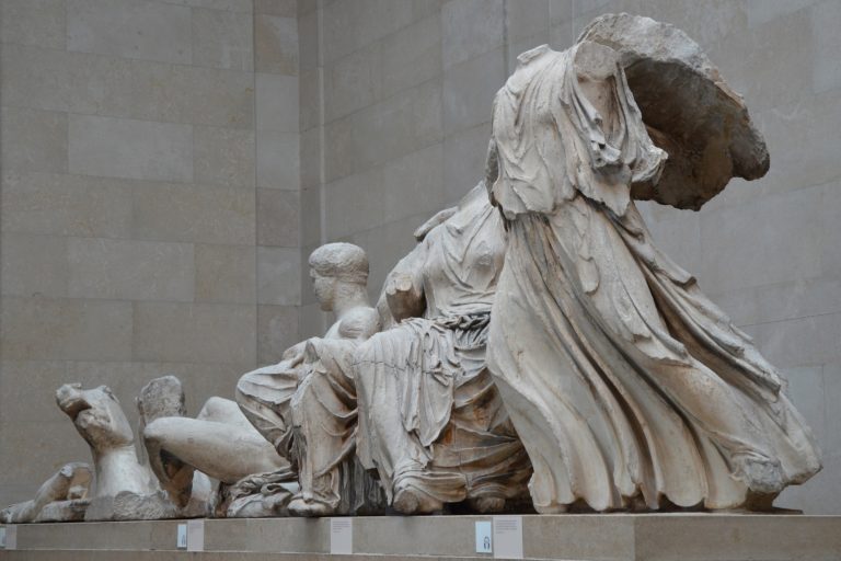 Marble figures from the Parthenon’s east pediment are arranged on a gallery platform at the British Museum.