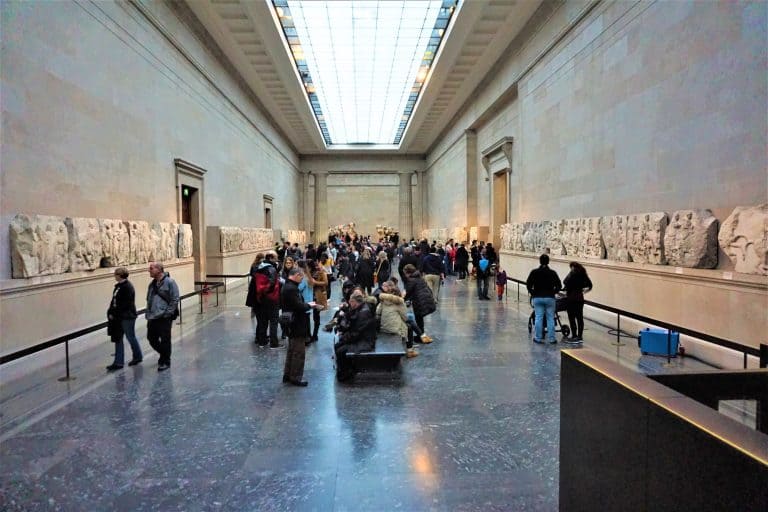 Parthenon marble sculptures stand on plinths in the British Museum’s Room 18, with carved relief panels lining the gallery walls.