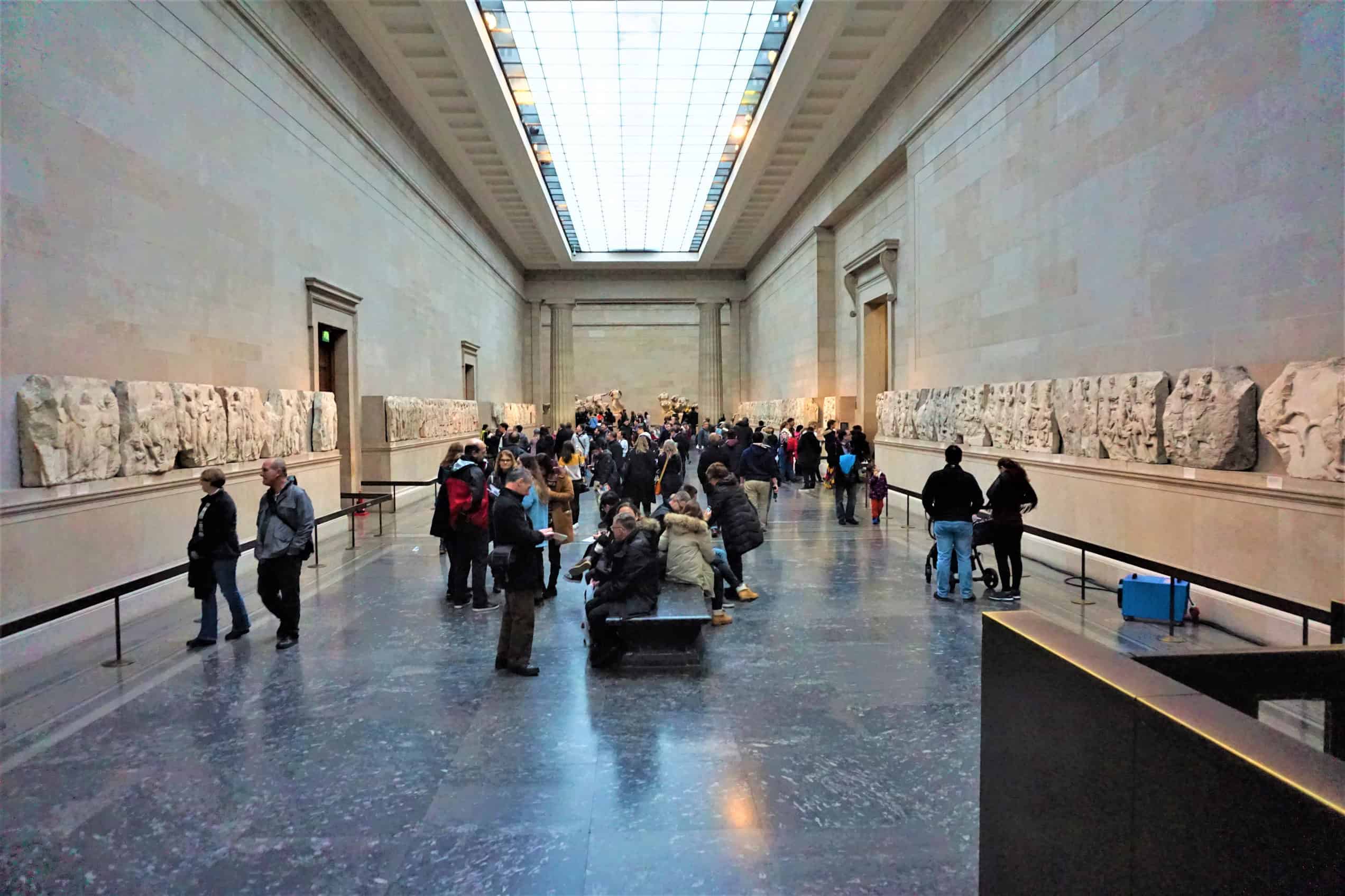 Parthenon marble sculptures stand on plinths in the British Museum’s Room 18, with carved relief panels lining the gallery walls.