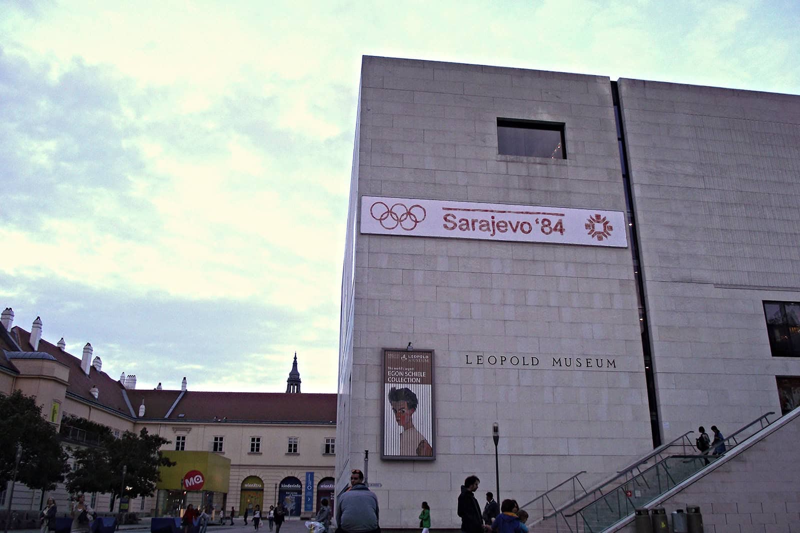 The white stone exterior of the Leopold Museum rises above Vienna’s MuseumsQuartier at dusk.