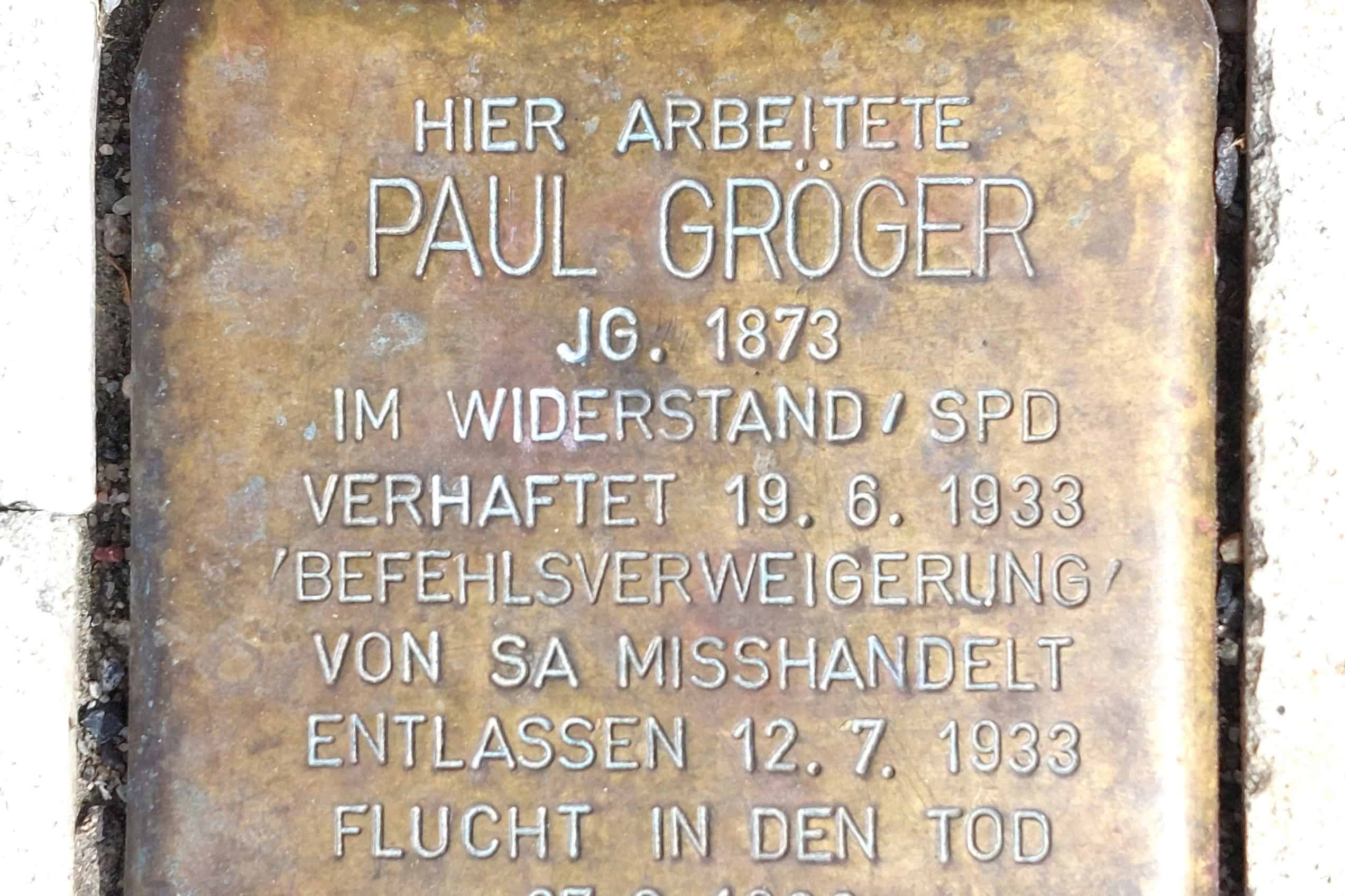 The brass Stolperstein for former Heidenau mayor Paul Gröger is embedded among gray paving stones.