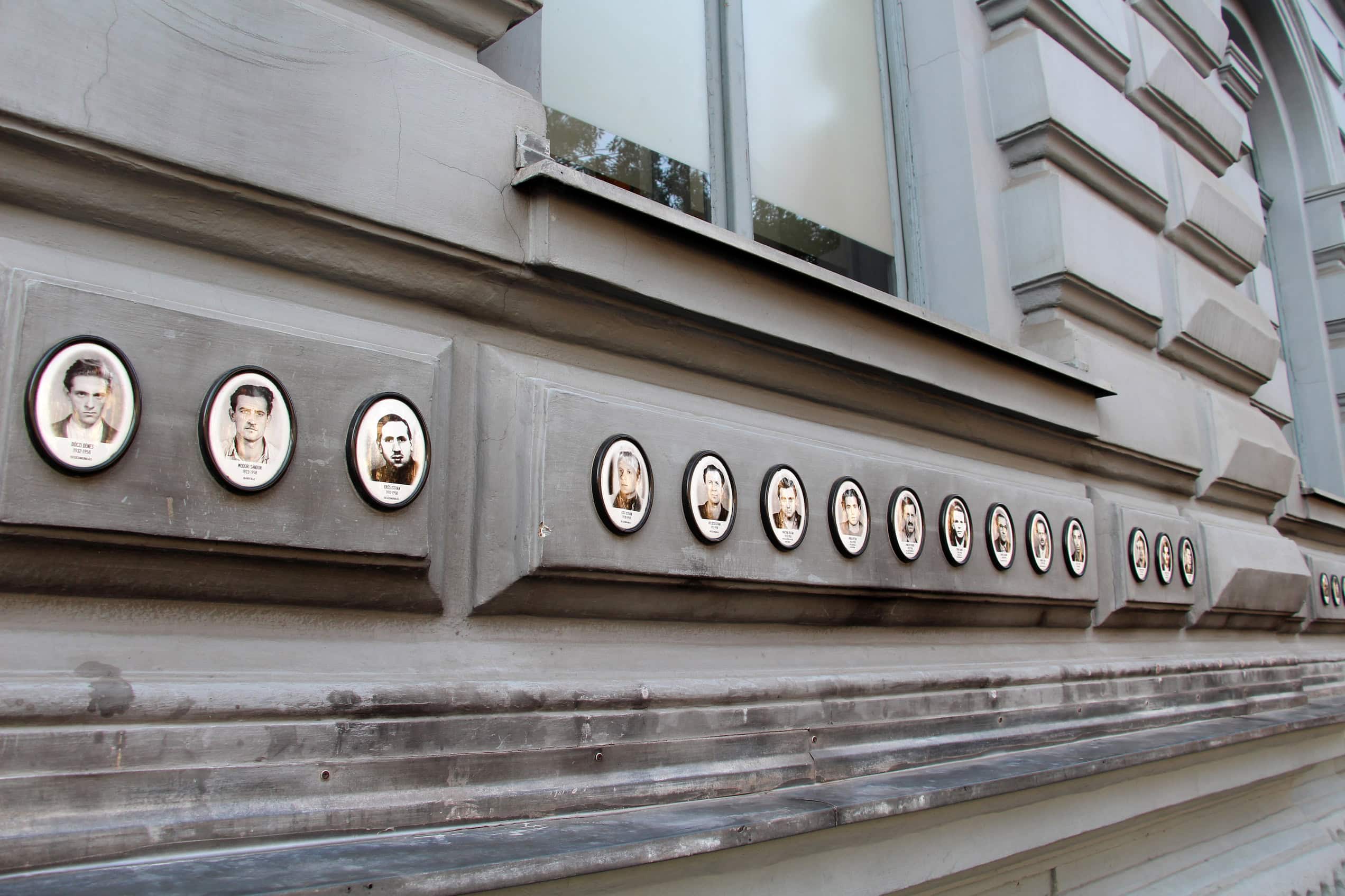The gray House of Terror Museum in Budapest stands beneath a black canopy spelling TERROR across its facade.
