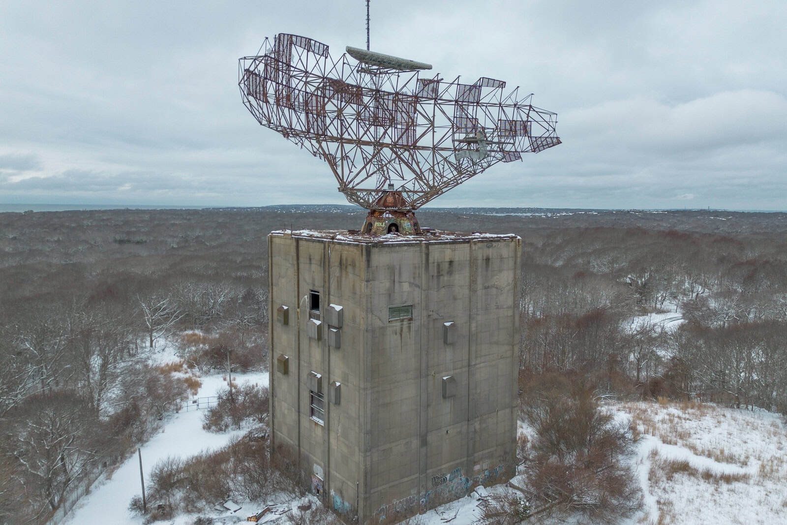 The skeletal AN/FPS-35 radar antenna stands above trees at Camp Hero State Park in Montauk.