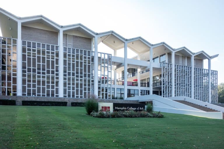 Rust Hall’s white mid-century facade and angular roofline rise above the lawn in Overton Park.