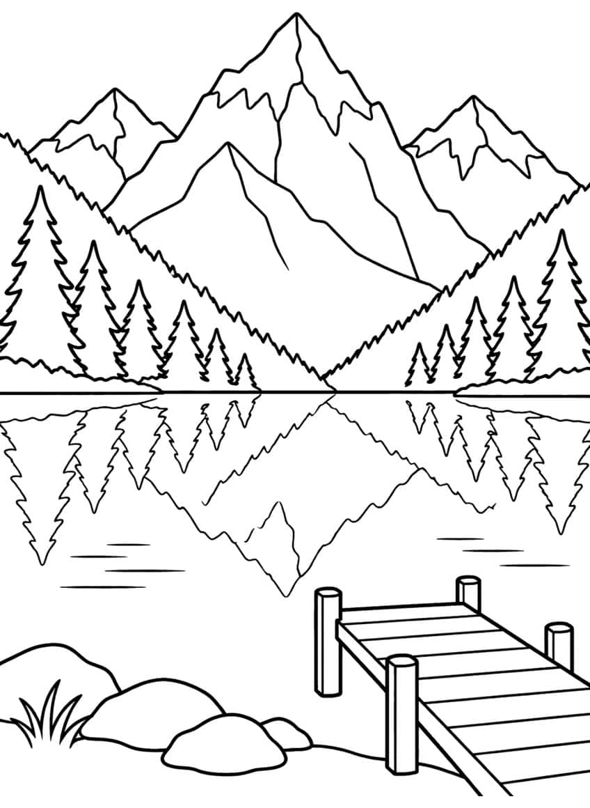 Mountain peaks and spruce trees reflected in a lake, with a wooden dock, boulders and grass in front