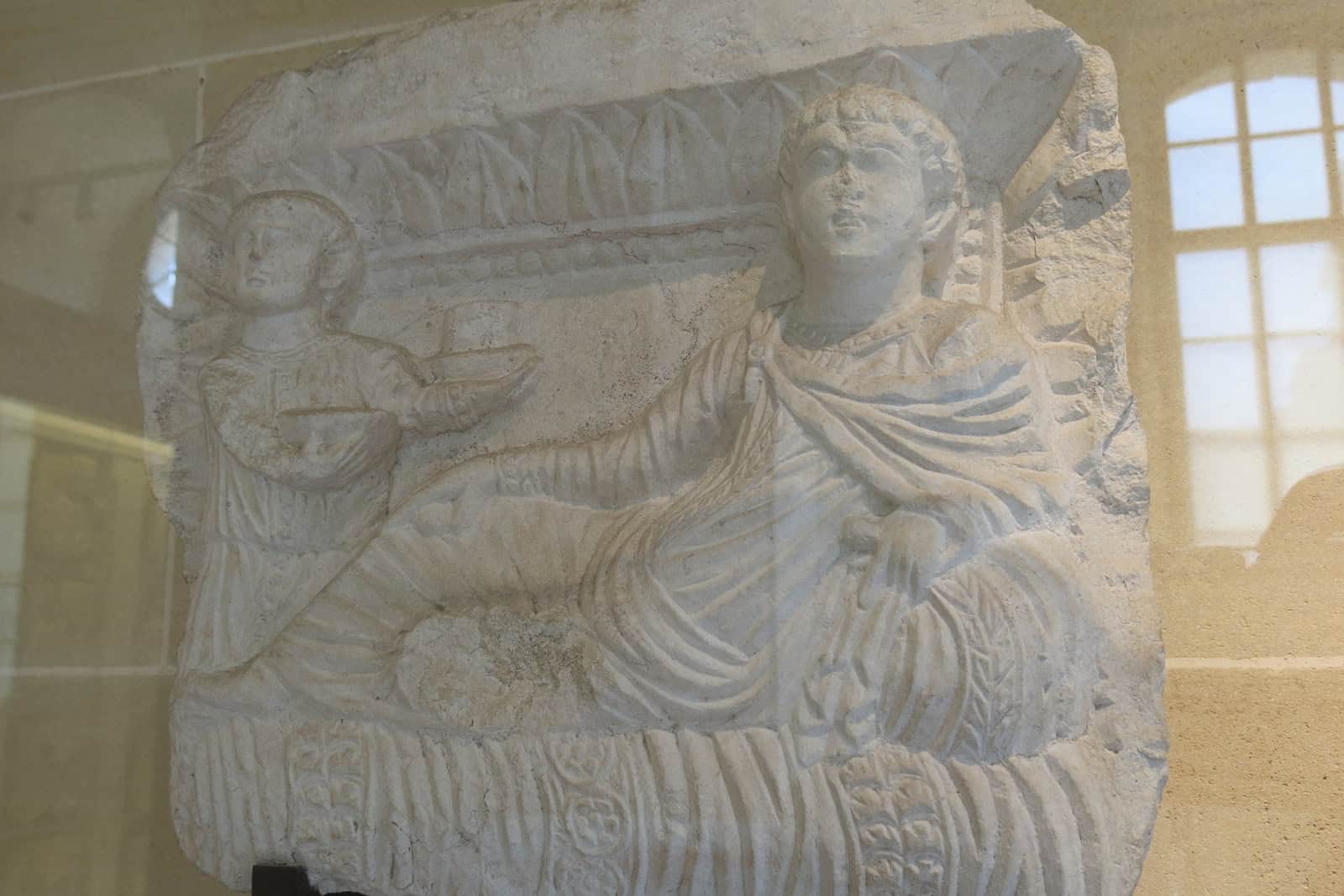 Late-second-century Palmyrene limestone funerary relief depicting a banquet scene.