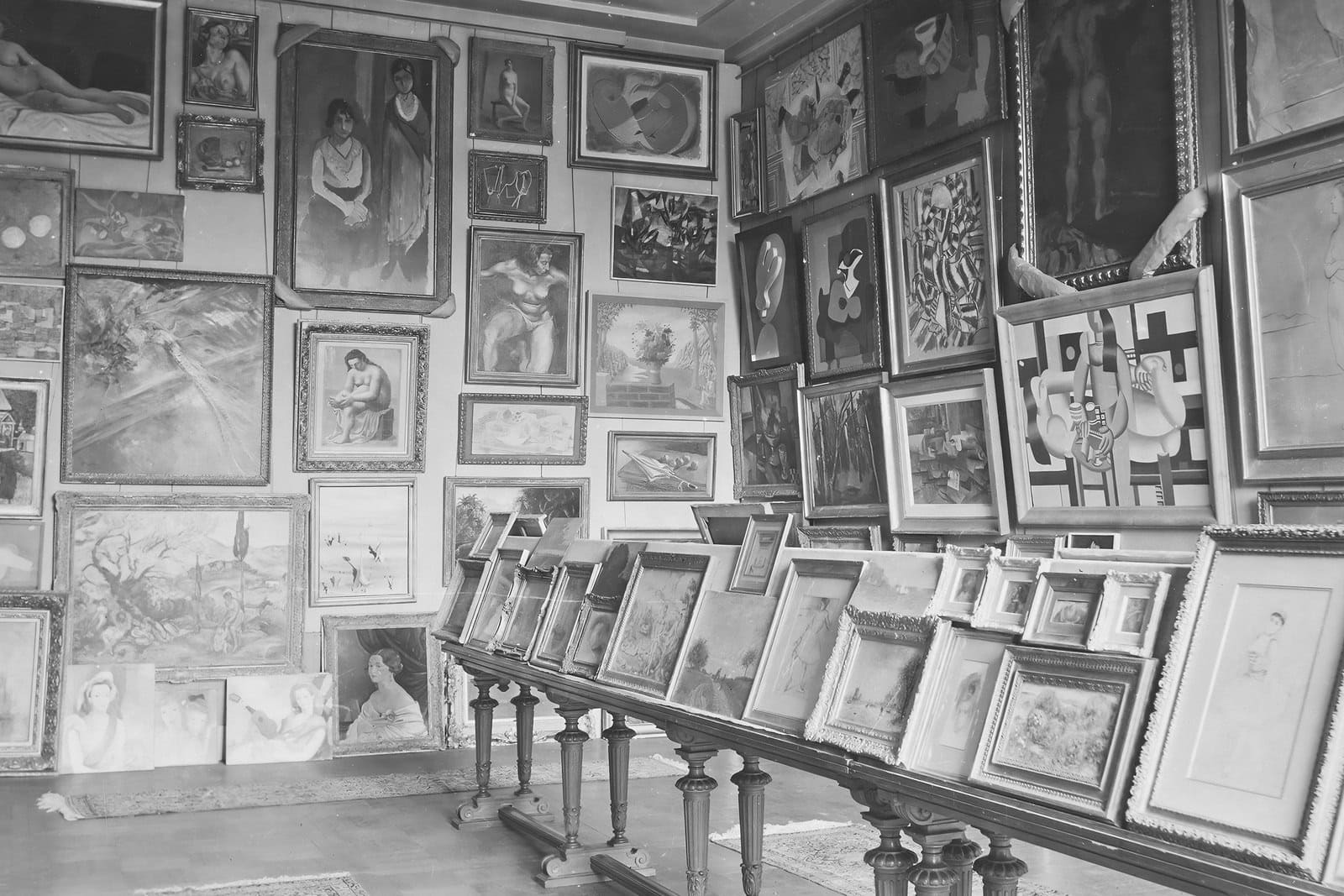 Black-and-white 1940 photograph of paintings crowded into the Jeu de Paume’s Salle des Martyrs in Paris.