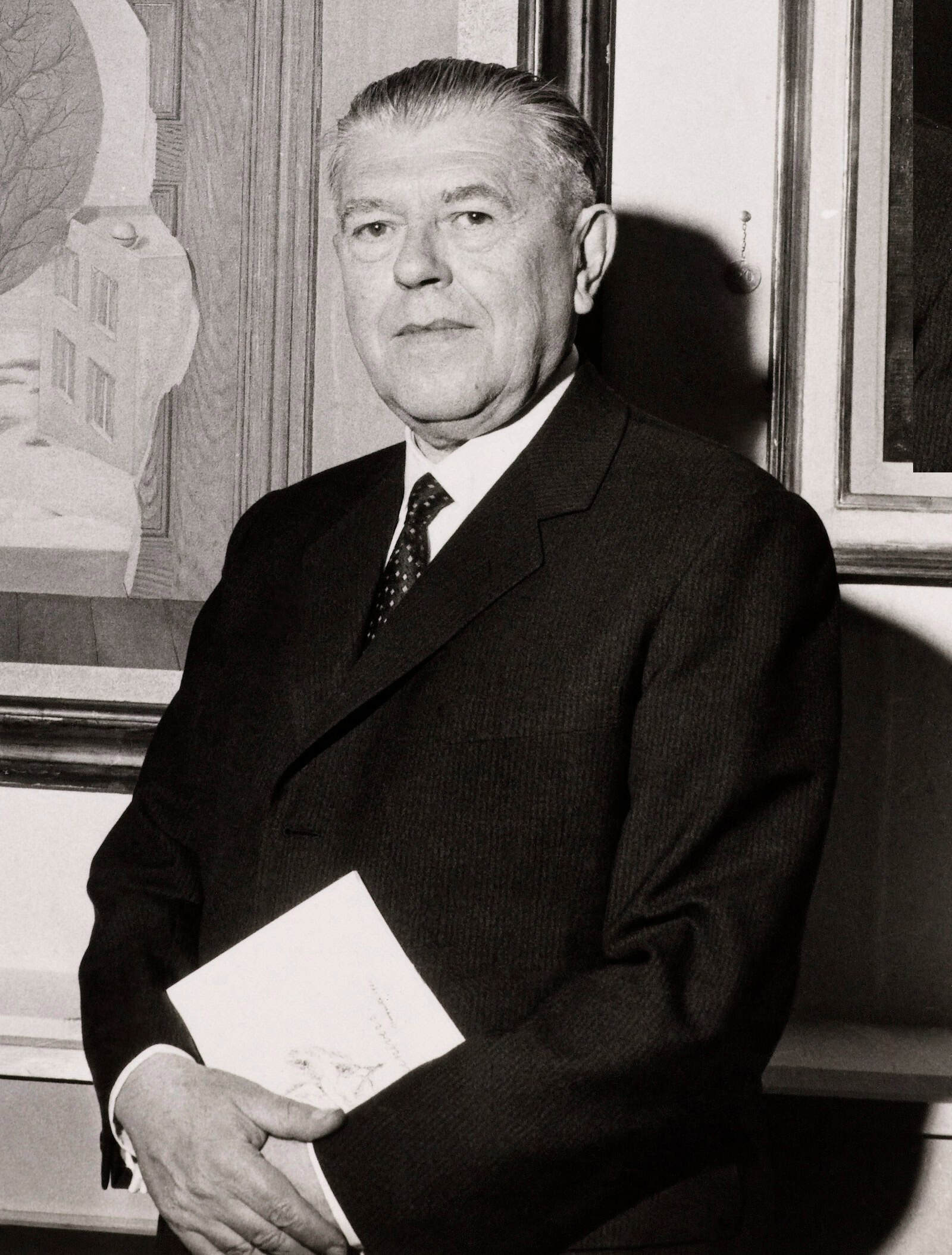 René Magritte photographed in 1961 before his 1935 painting La perspective amoureuse.