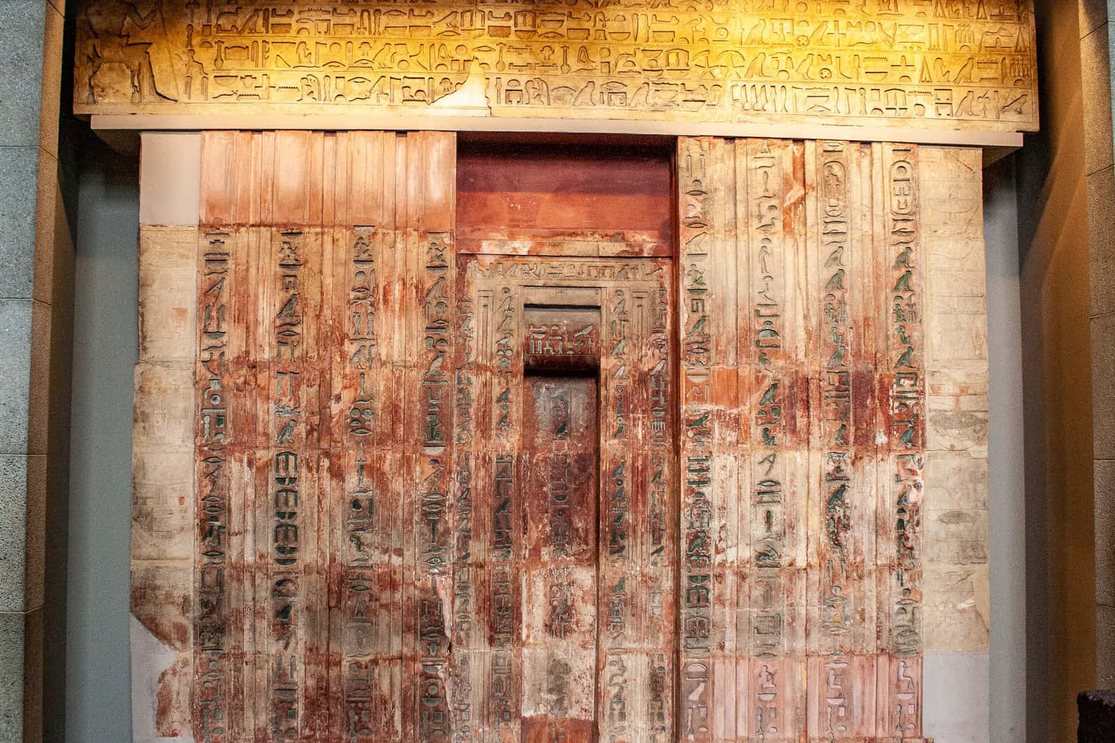 The limestone false door and architrave of Ptahshepses are covered with carved hieroglyphs and offering imagery, with traces of painted color.