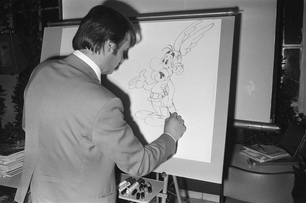 Albert Uderzo sits at a table drawing Asterix during a 1971 appearance in Amsterdam.