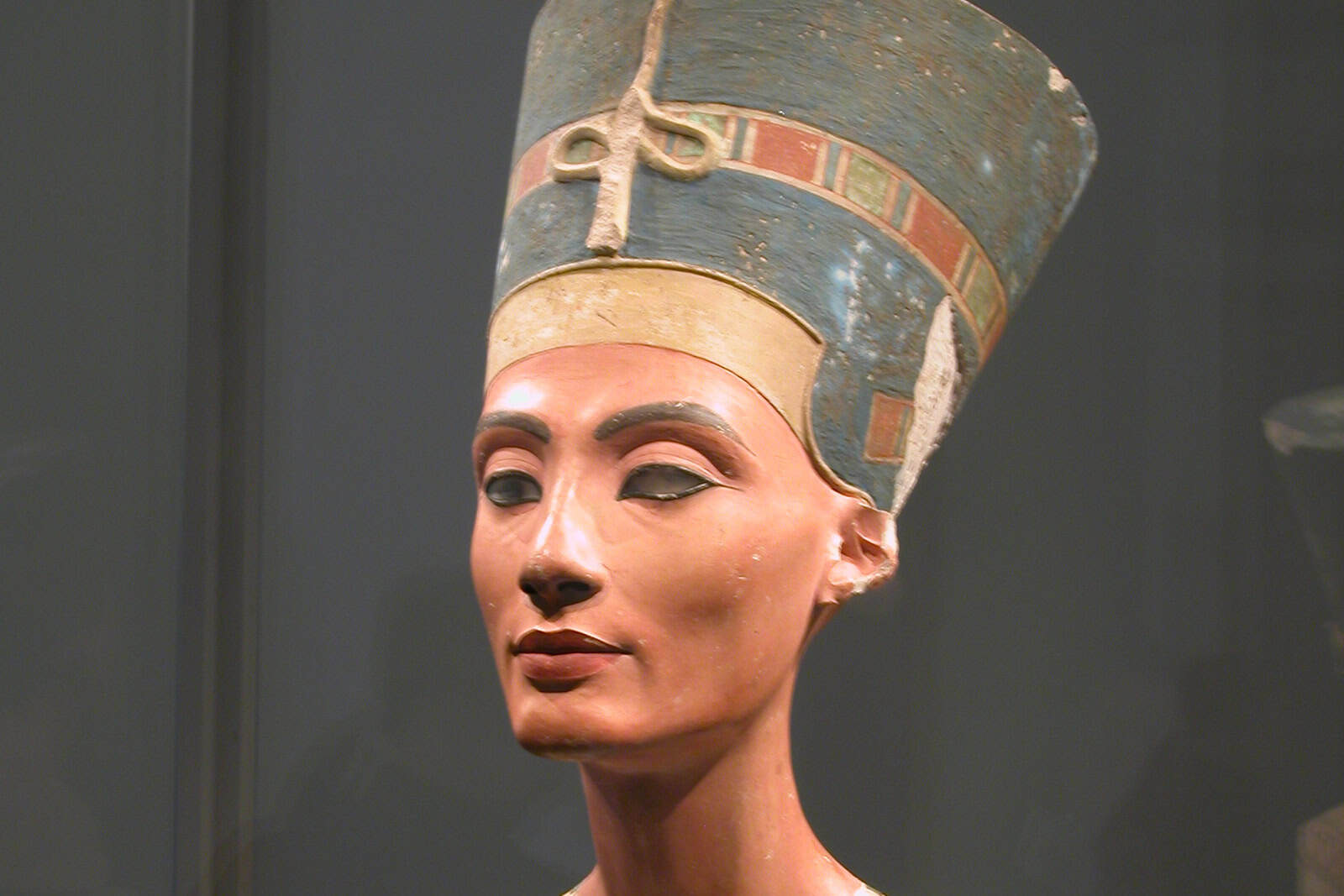 The painted limestone bust of Nefertiti, wearing its tall blue crown.