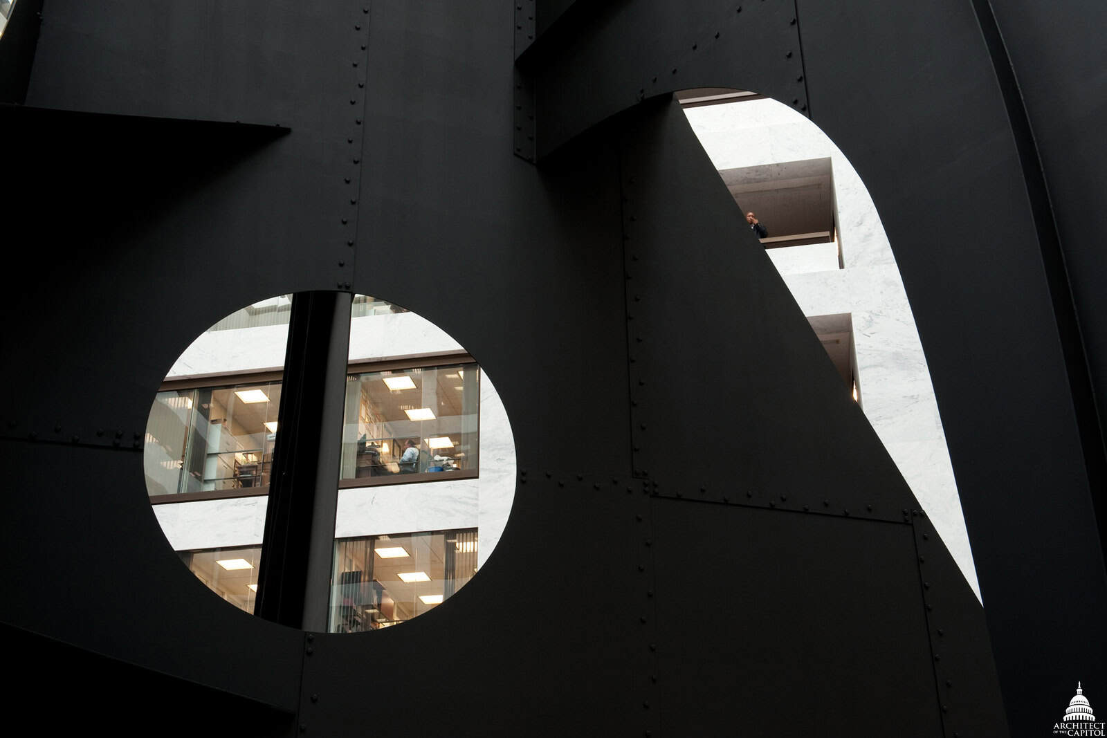 Angular black steel mountain forms from Calder’s Mountains and Clouds rise inside the white Hart Building atrium.