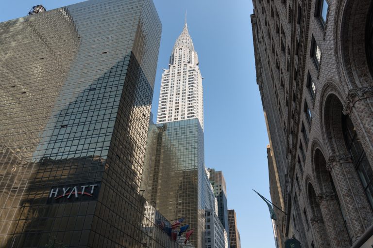 The Chrysler Building rises above Midtown Manhattan in a wide exterior view.
