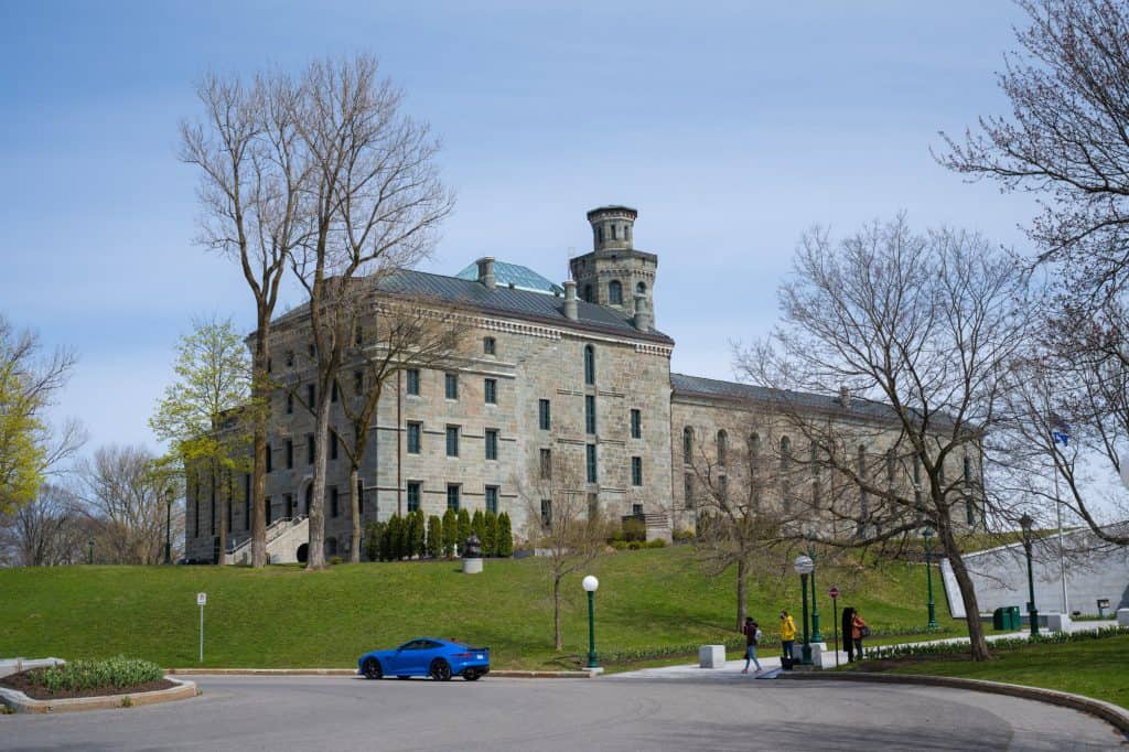 The limestone Musée national des beaux-arts du Québec building stands beyond a lawn and paved path in Quebec City.