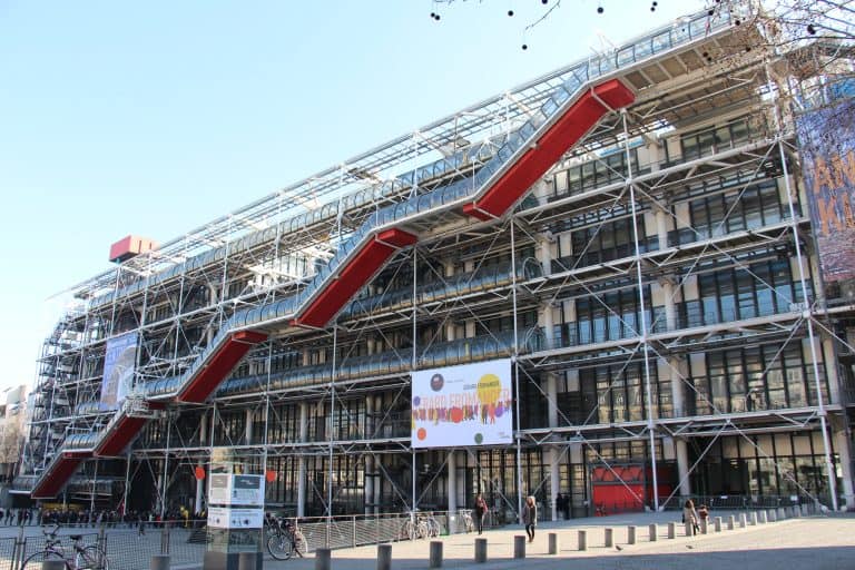 The Centre Pompidou’s colorful exterior pipes, exposed steel structure, and diagonal escalator overlook its Paris plaza.