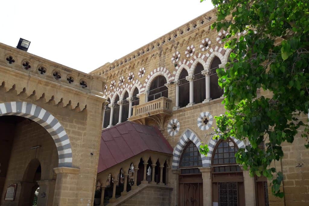 Frere Hall rises behind its garden in Karachi under a clear blue sky.