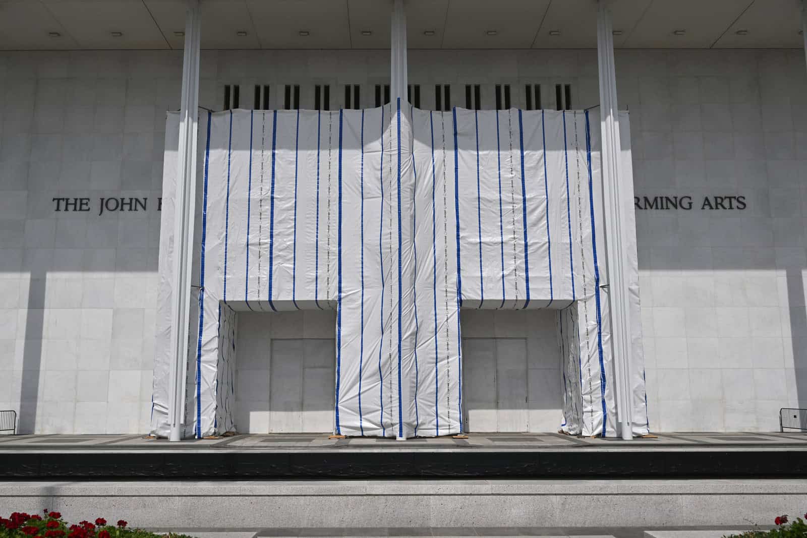 Scaffolding and white sheeting cover much of the Kennedy Center’s facade and sign in June 2026.