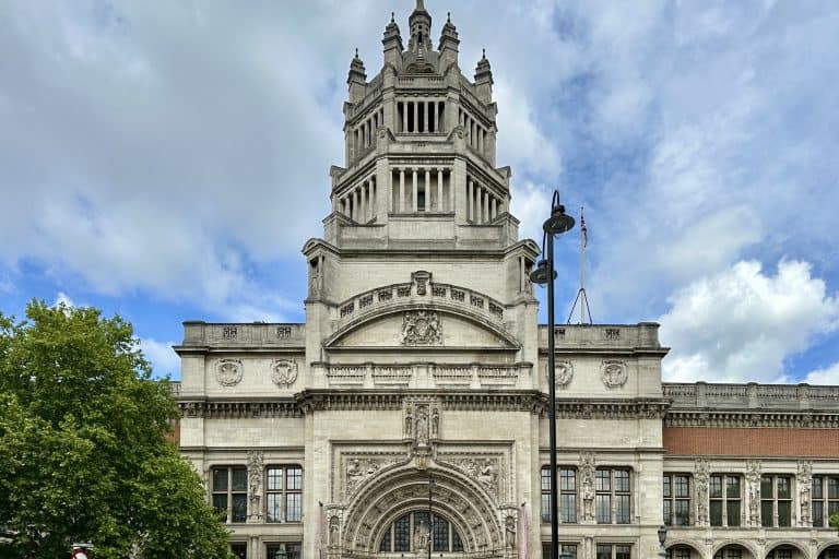 The red-brick and pale-stone facade of the Victoria and Albert Museum in London viewed from the street.