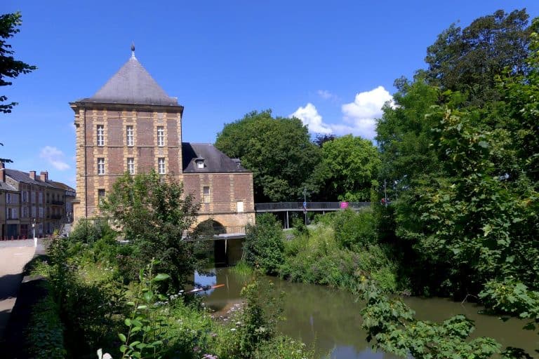 The Musée Arthur Rimbaud stands beside the Meuse in Charleville-Mézières under a blue sky.