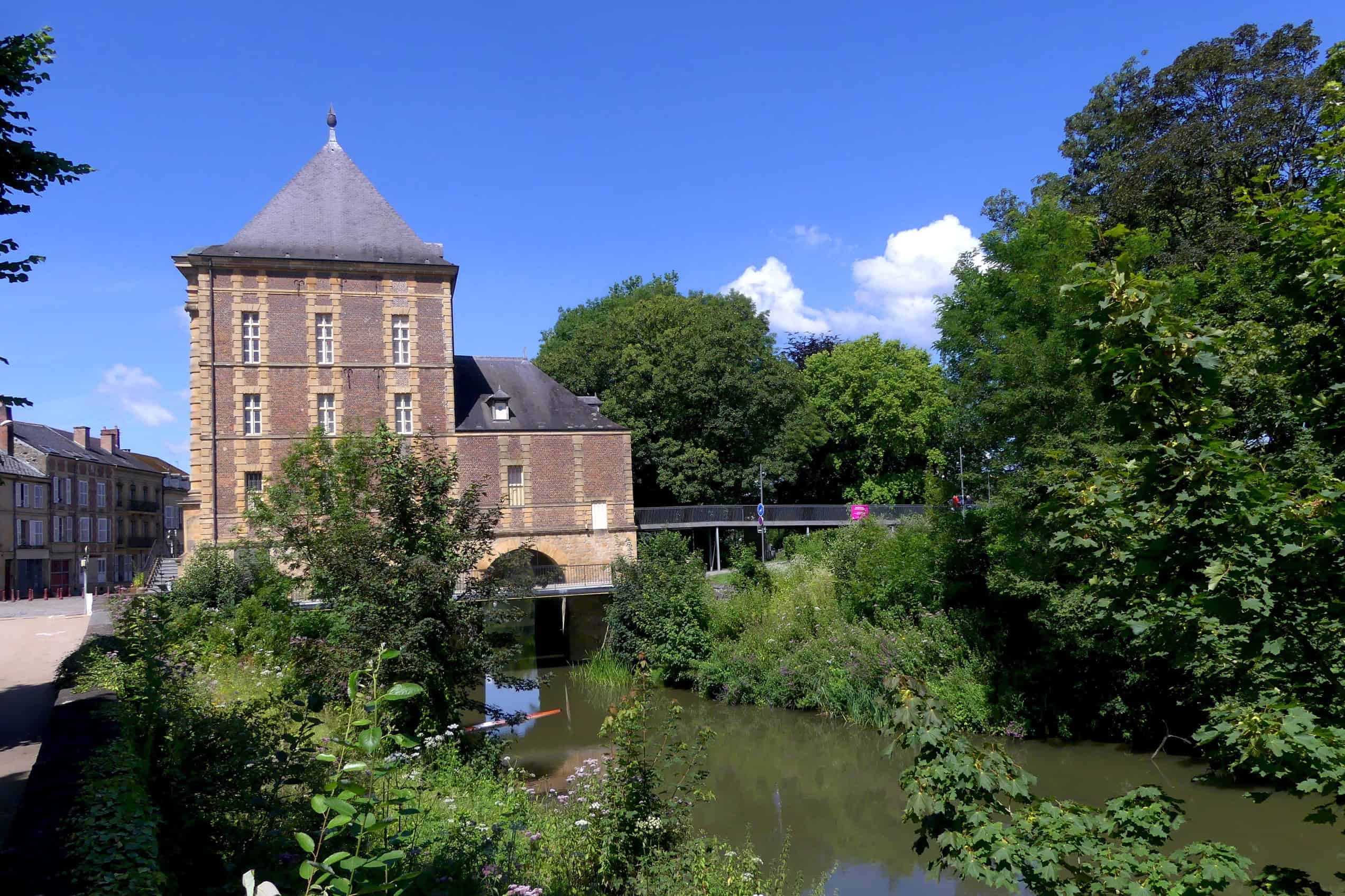 The Musée Arthur Rimbaud stands beside the Meuse in Charleville-Mézières under a blue sky.