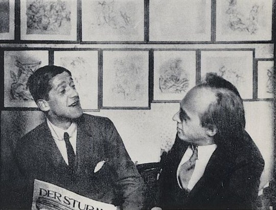 Kokoschka and Herwarth Walden in Walden's Berlin graphic room in 1916, with Kokoschka drawings on the walls.