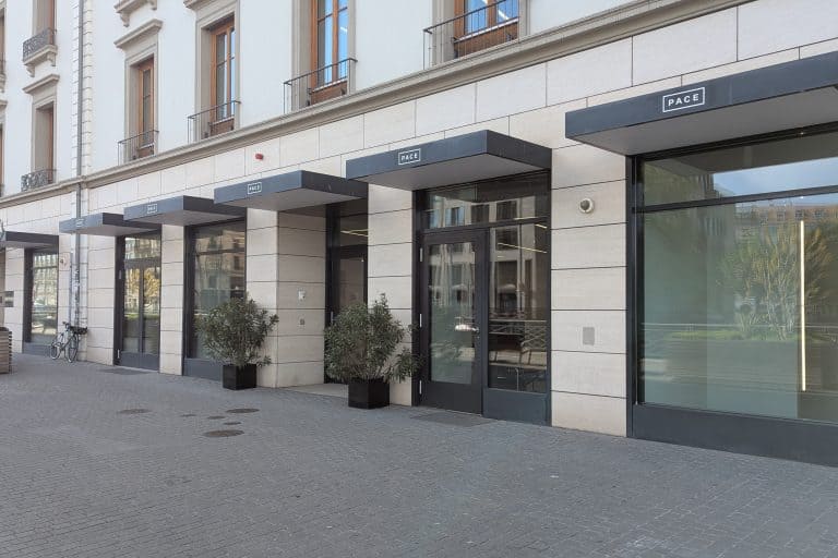 The glass-fronted Pace Gallery in Geneva stands beside the Rhône on a sunny day.