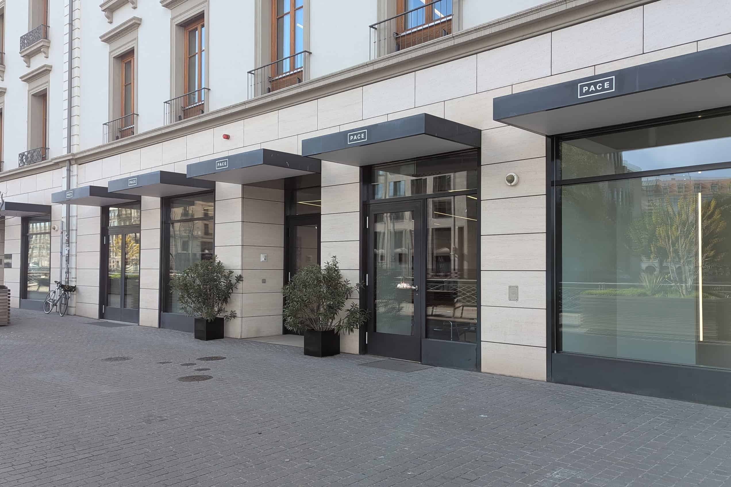 The glass-fronted Pace Gallery in Geneva stands beside the Rhône on a sunny day.