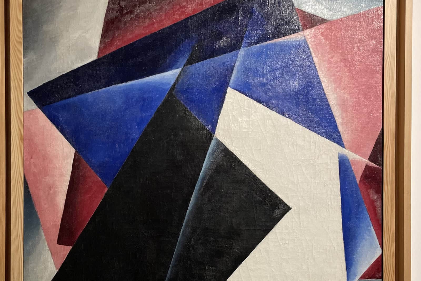 Intersecting red, black, white, and ocher geometric forms fill Lyubov Popova’s 1918 abstract painting.