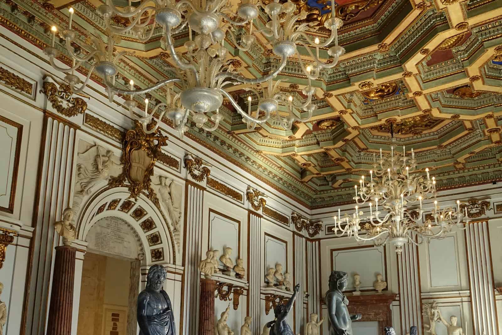 The marble-lined Salone of Palazzo Nuovo has sculptures arranged around its walls beneath a high decorated ceiling.