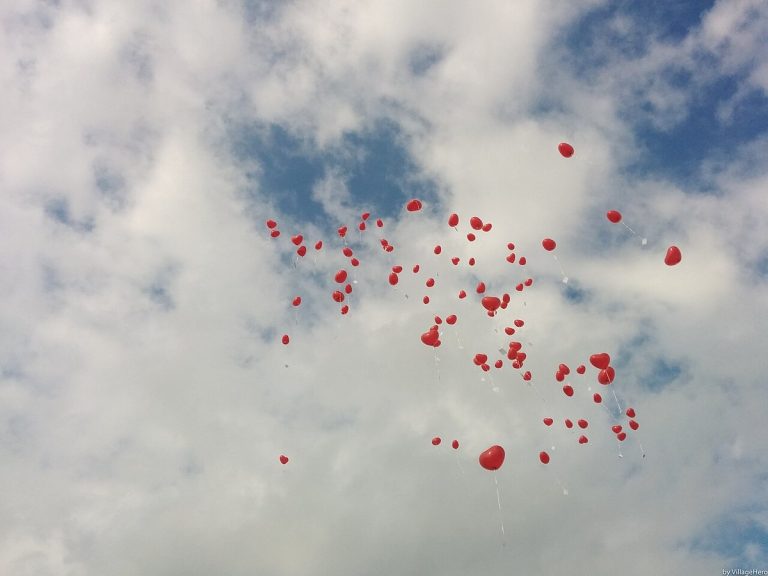 Red balloons drifting into the sky